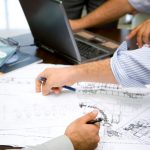 Engineers in a meeting working on design plans for doors at K2 doors