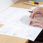 K2 Design services, a person working with a ruler and door design plans on a desk
