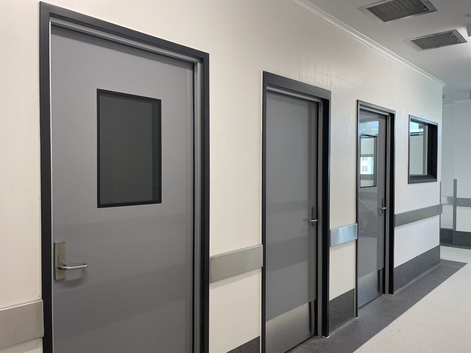 A hallway with three hygienic doors in a medical setting.